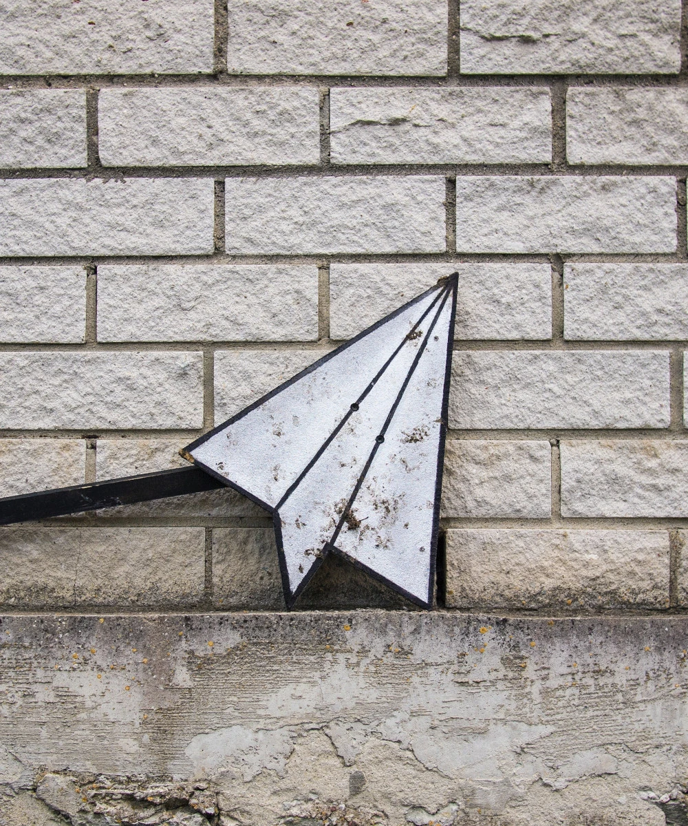 A paper plane staying laid to wall.